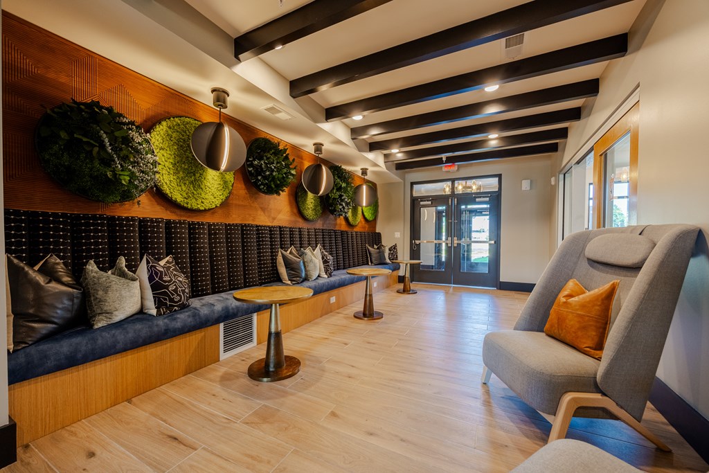 A long hallway with a bench and plants on the wall.