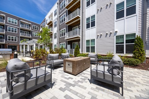 A patio area with grey furniture and a wooden box in the middle.