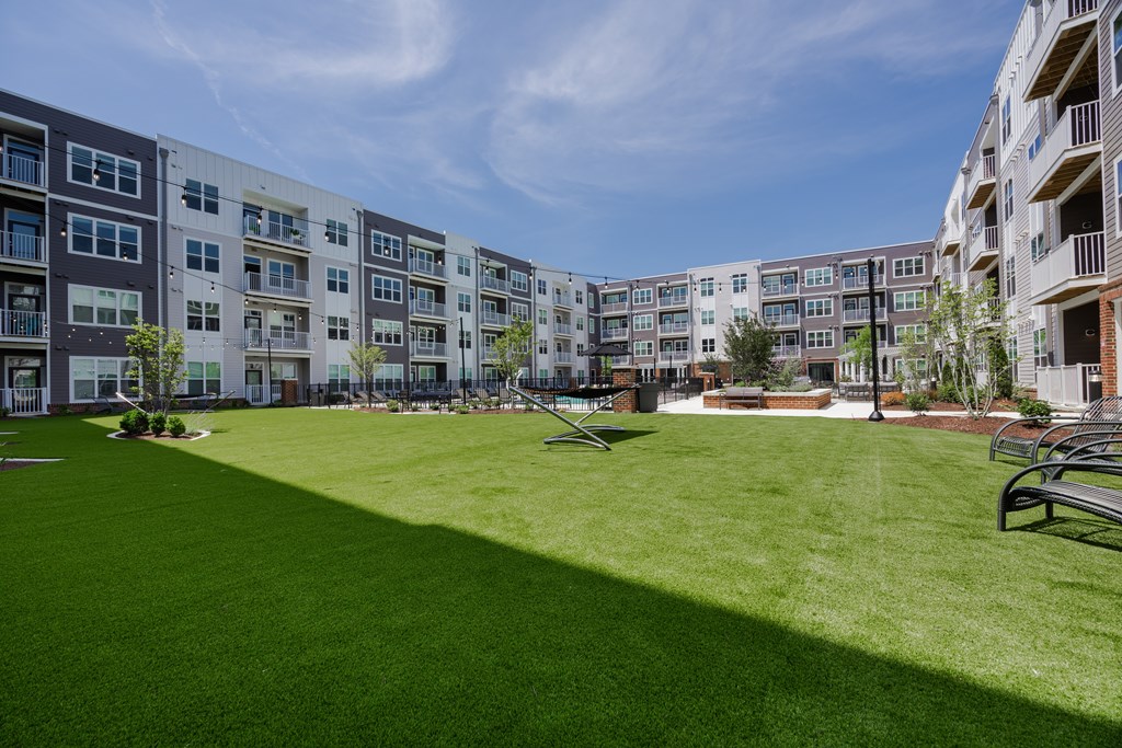 A grassy area in front of apartment buildings.