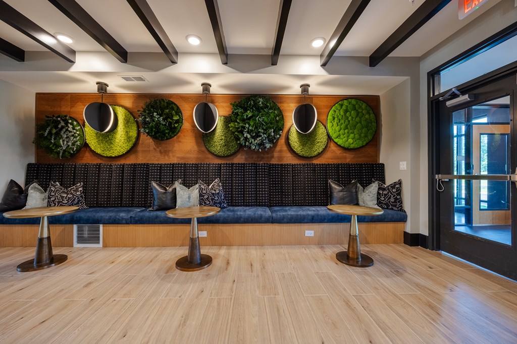 A modern waiting area with a green wall and a black couch.