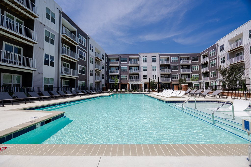 A large swimming pool in front of apartment buildings.