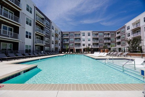 A large swimming pool in front of apartment buildings.