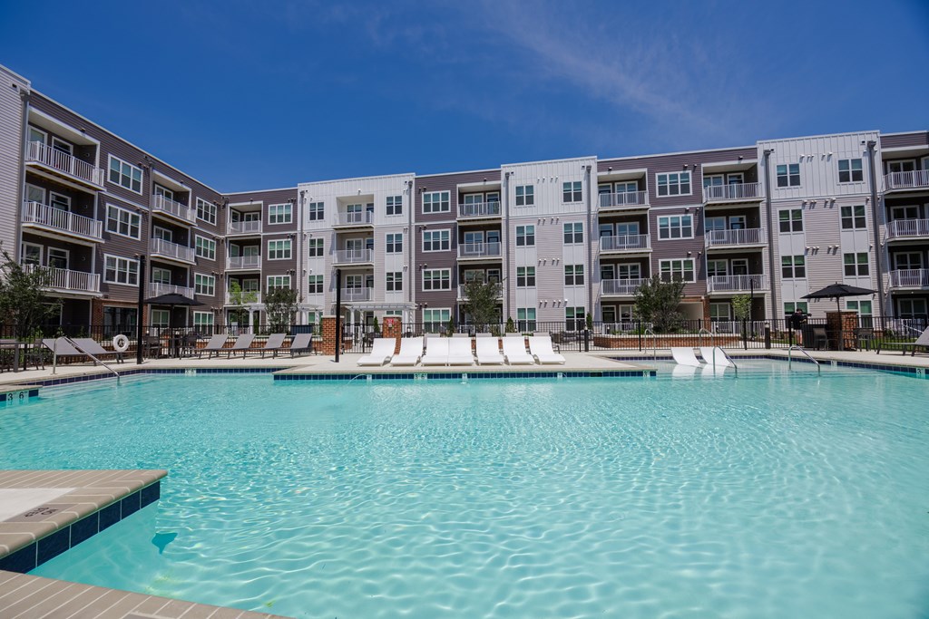 A large swimming pool in front of apartment buildings.