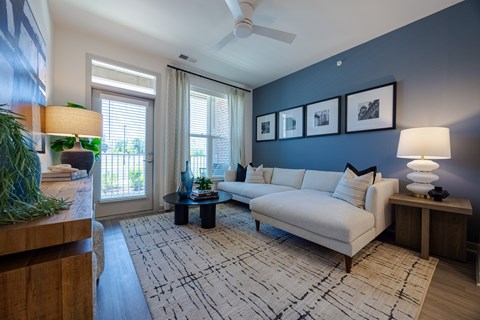 A living room with a white couch and a rug.