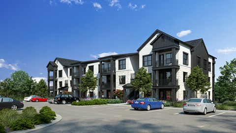 A modern multi-story building with a parking lot in front.