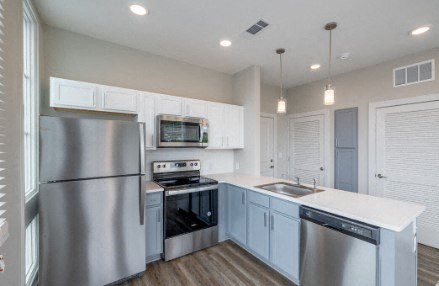 A modern kitchen with stainless steel appliances and white cabinets.