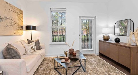 A living room with a white couch, a coffee table, and a large painting on the wall.