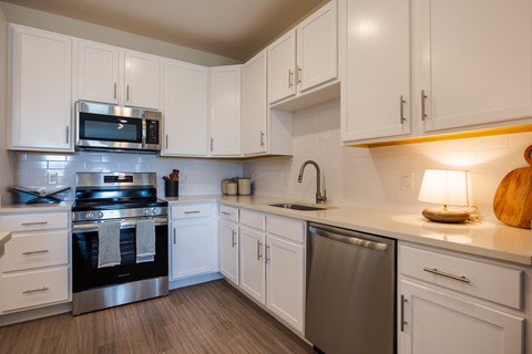 A kitchen with white cabinets and a stainless steel dishwasher.