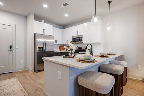 A kitchen with a white counter and a refrigerator.