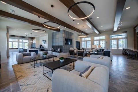 A modern living room with a dark wood floor and white furniture.