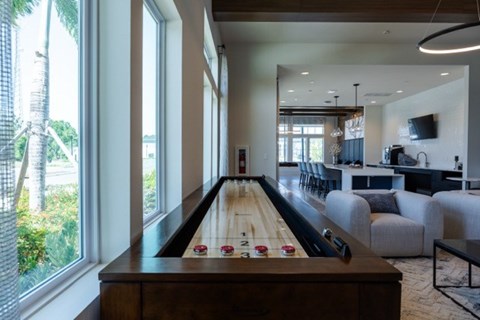 A pool table is in the middle of a room with a TV and a couch.