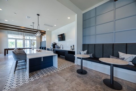 A modern kitchen with a blue island and a black and white tiled floor.