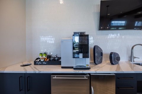 A modern kitchen with a coffee machine and a sink.