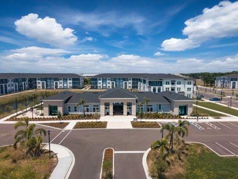 A large building complex with a parking lot in front.
