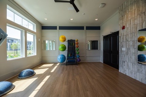 A room with a wooden floor and a wall with a stone pattern.