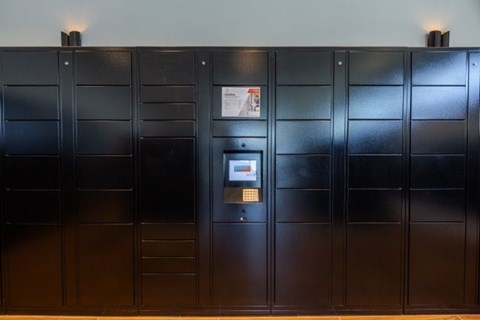 A black door with a keypad and a sign on it.