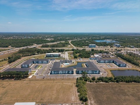 An aerial view of a large building complex surrounded by a lake and a road.