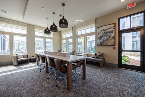 A conference room with a long table, chairs, and a view of the city.