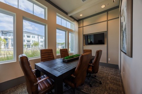 A conference room with a large table and chairs.