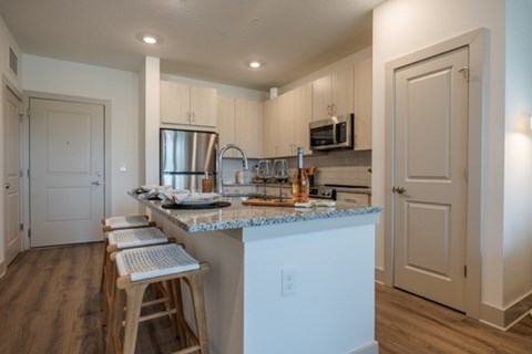 A kitchen with a white island and wooden floors.