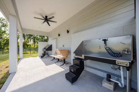 A patio with a grill and a fan.