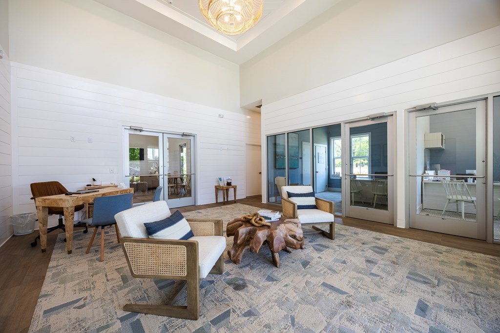 A living room with a grey carpet and wooden furniture.
