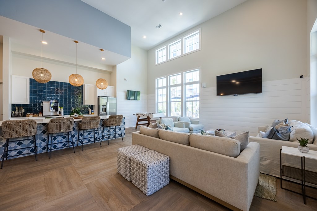 A living room with a white couch and a television on the wall.