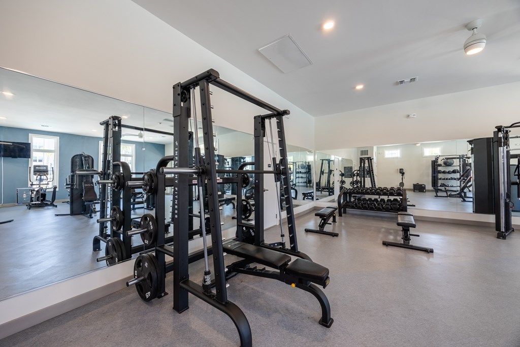 A gym with a variety of equipment including a squat rack.