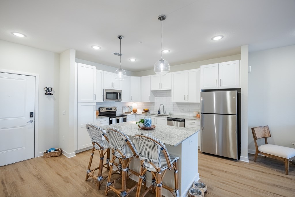 A kitchen with a white island and a refrigerator.