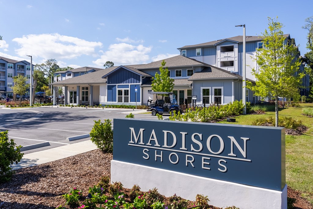 A sign that says "Madison Shores" in front of some houses.