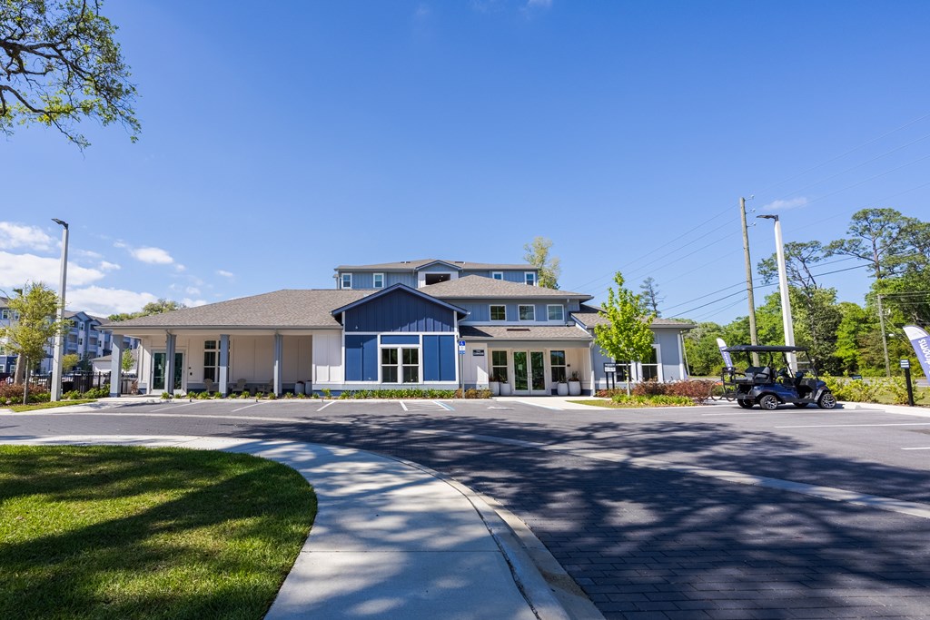 A blue and white building with a parking lot in front.