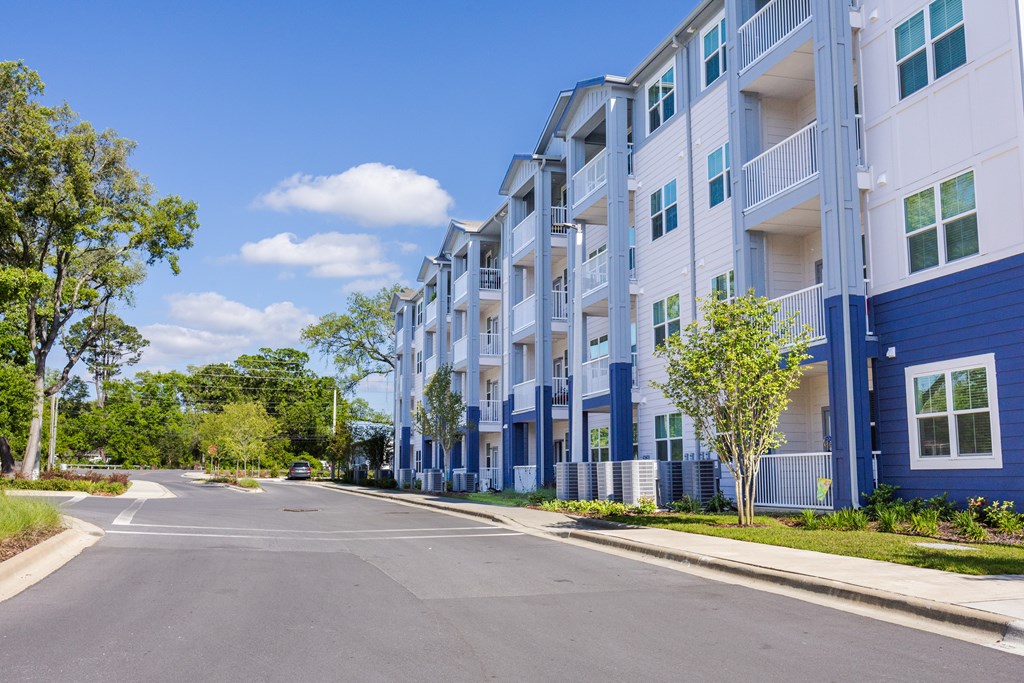 A street view of a residential area with apartment buildings on the right.