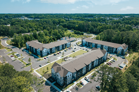 A large apartment complex surrounded by trees.