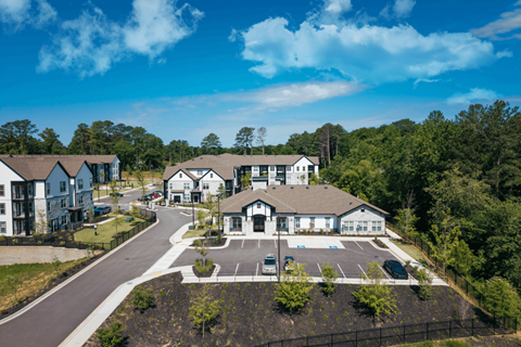 A bird's eye view of a residential area with houses and a parking lot.