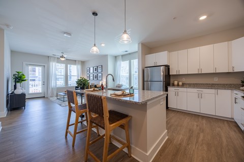 A kitchen with a table and chairs in front of a window.
