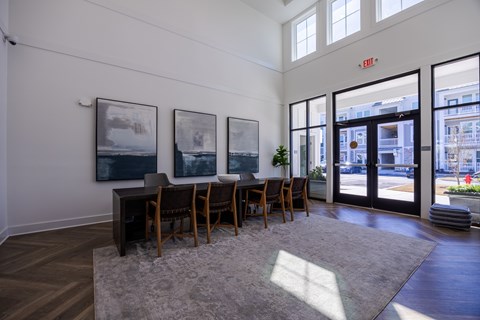 A room with a table and chairs and a large window.