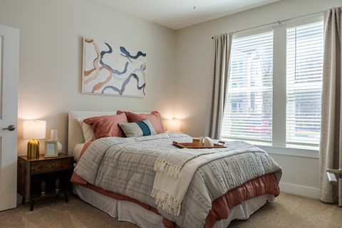 A bedroom with a large bed and a painting on the wall.