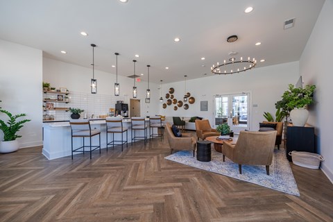 A well-lit, spacious living room with a bar area and comfortable seating.