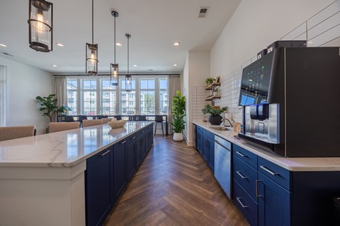 A modern kitchen with dark blue cabinets and a white countertop.