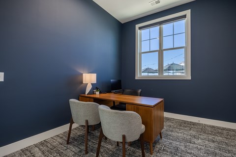 A room with a desk and two chairs.