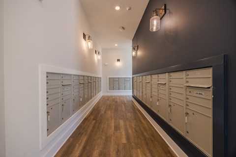 A long hallway with a row of mailboxes on the wall.