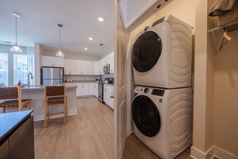 A white front loading washing machine is in a laundry room.