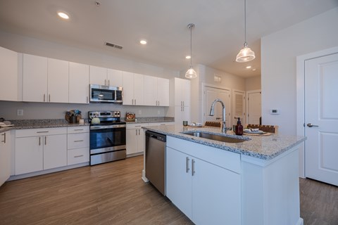 A kitchen with white cabinets and a granite countertop.