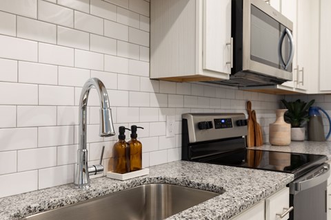 A kitchen with a sink and a microwave.