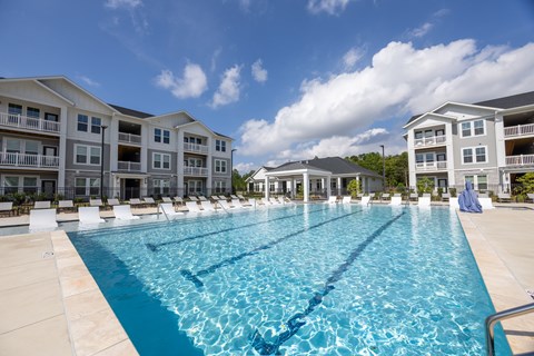 A large swimming pool in front of apartment buildings.