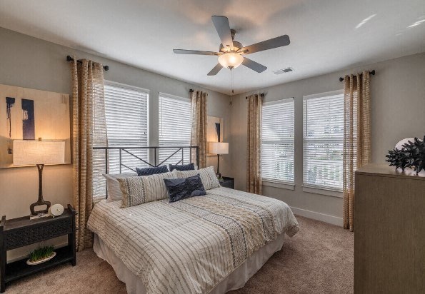 a bedroom with a bed and a ceiling fan