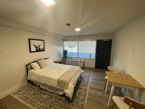 A bedroom with a bed, desk, and chair.
