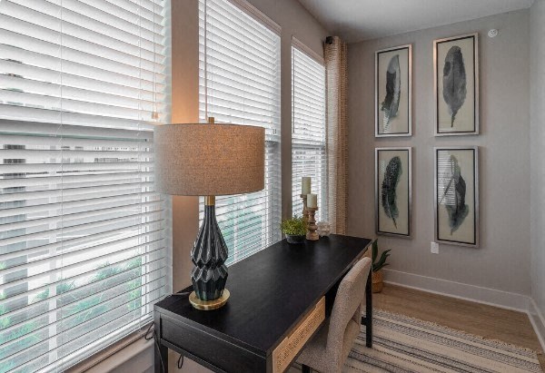 a living room with a desk and a lamp