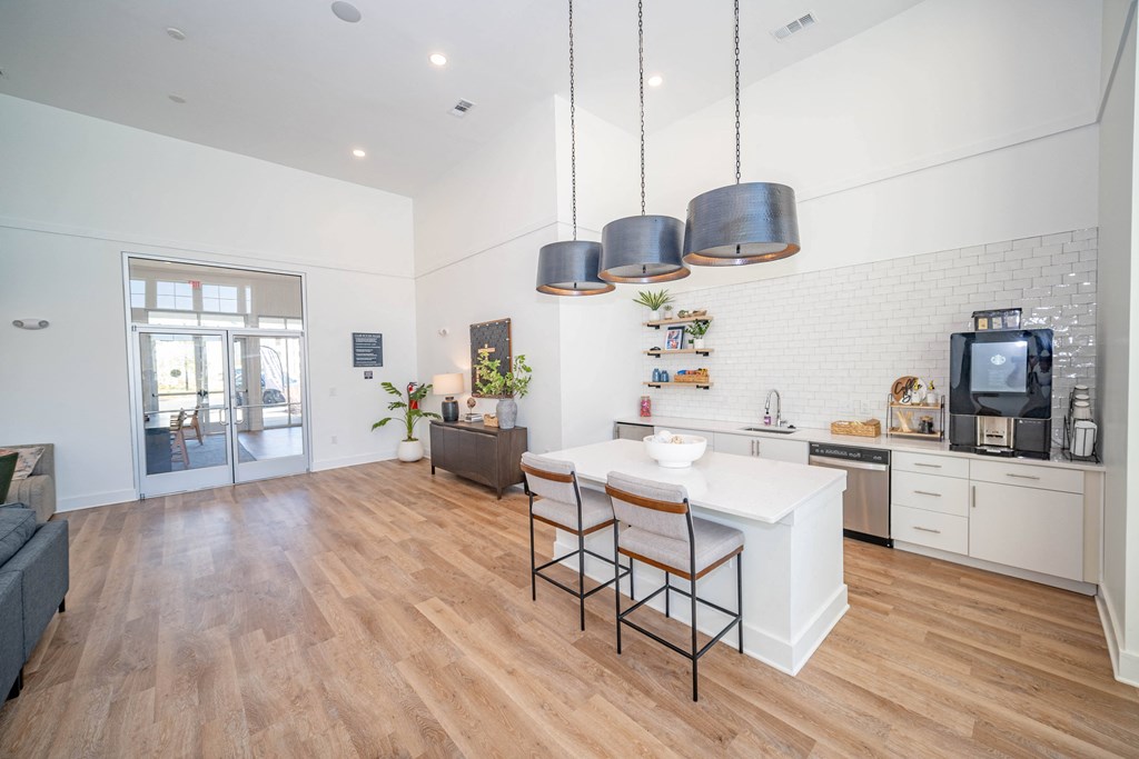 a kitchen and living room with a white counter top and a tv