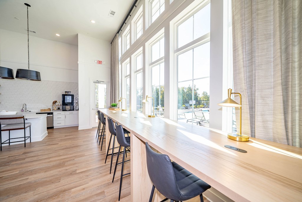 a long bar with chairs in front of a large window